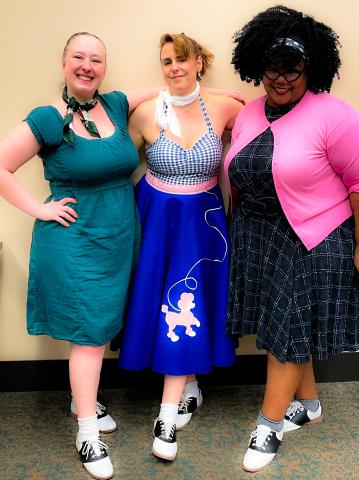 Three women posing in 1950s clothing
