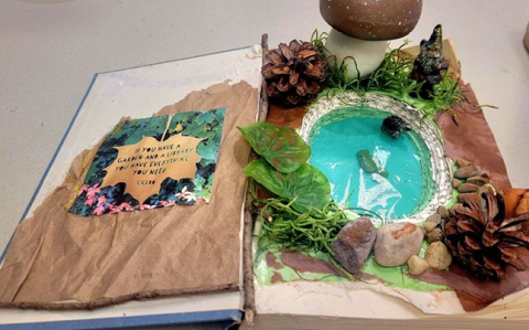 open book with fairy garden pieces attached
